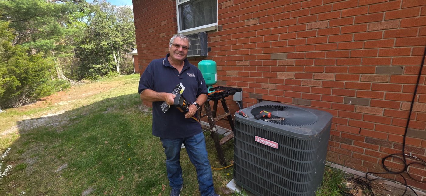 John Dublon of Affordable Services working beside a Goodman air conditioning condenser in New Jersey